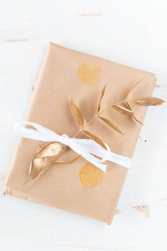 Geschenke hübsch verpacken und mit goldenen Zweigen verzieren